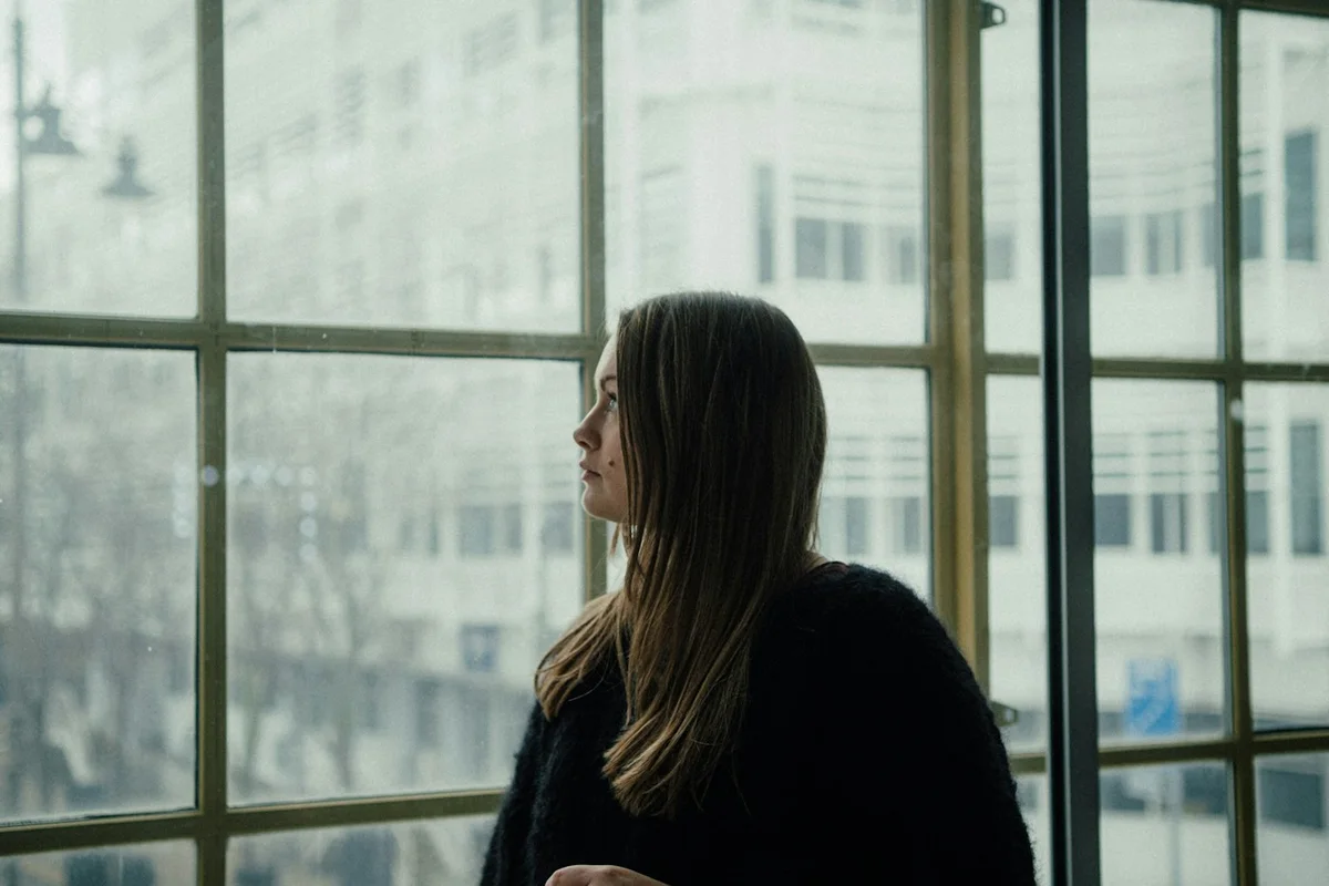 Una persona hace una pausa junto a una ventana